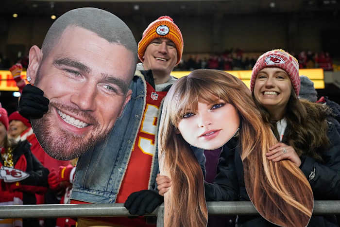 Chiefs fans wave Taylor Swift and Travis Kelce cutouts at Arrowhead Stadium. © Sam Greene / USA TODAY NETWORK